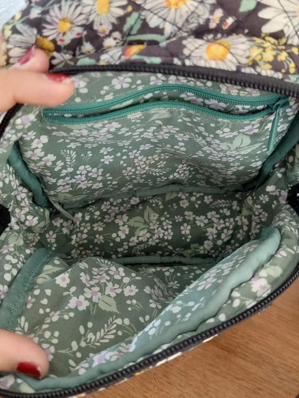 Vera Bradley Daisy Floral Backpack with white daisies and yellow centers on a da